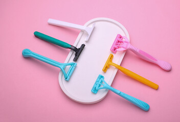 Different disposable razors with tray on a pink background