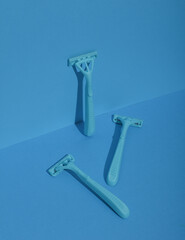 Blue disposable razors on blue background. Creative layout. Minimalism