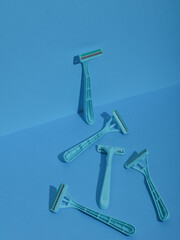 Blue disposable razors on blue background. Creative layout. Minimalism