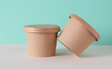 Eco cardboard round food box on table, mint green background