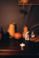 Creative Halloween pumpkin arrangement with candle and origami bat decor
