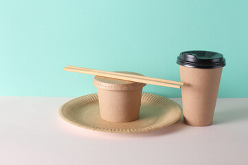 Cardboard takeaway food containers and dishes on mint green background