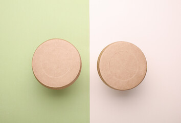 Eco cardboard round food boxes on green beige background. Top view