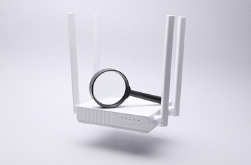 Modern white four-antenna Wi-Fi router and magnifying glass floating on gray background.