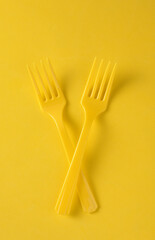 Set of plastic forks on yellow background