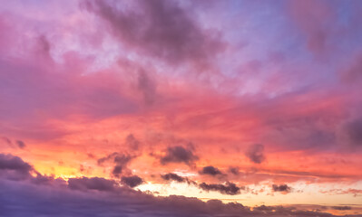 A beautiful sky tinted by the sun leaving vibrant shades of gold, pink, blue and multicolored. Clouds in the twilight evening and morning sky. Cloudy sky background in the evening, and during the day.