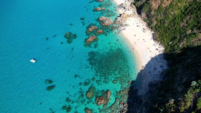 4K Aerial drone video of one of the most beautiful beaches in the world with turquoise clear blue water and white sand with big rocks on a sunny summer day. Marinella di Zambrone Paradiso Tropea Italy