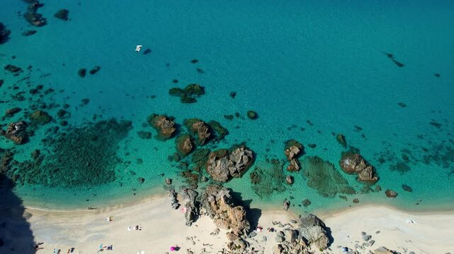 4K Aerial drone video of one of the most beautiful beaches in the world with turquoise clear blue water and white sand with big rocks on a sunny summer day. Marinella di Zambrone Paradiso Tropea Italy
