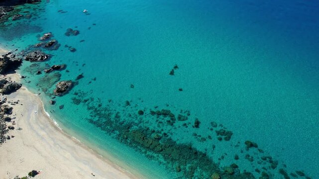 4K Aerial drone video of one of the most beautiful beaches in the world with turquoise clear blue water and white sand with big rocks on a sunny summer day. Marinella di Zambrone Paradiso Tropea Italy
