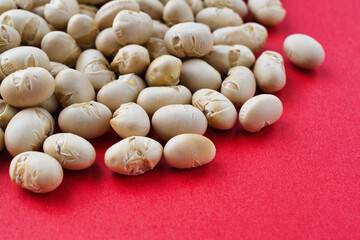 日本の節分：節分豆  (節分の豆)　赤背景　コピースペースあり　背景素材　Japanese Setsubun: Setsubun beans on a red background with copy space, Background material