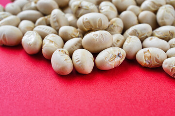 日本の節分：節分豆  (節分の豆)　赤背景　コピースペースあり　背景素材　Japanese Setsubun: Setsubun beans on a red background with copy space, Background material