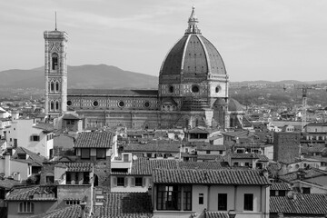 Fototapeta premium Black and white photo of the historic part of the city of Florence (Italy) with the Cathedral Cattedrale di Santa Maria del Fiore in the center of the photo against the background of the mountains