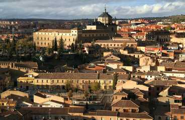 View of the historic part of the city with the Hospital Tavera building in the center of the photo against a stormy sky in the city of Toledo, near Madrid, Spain
