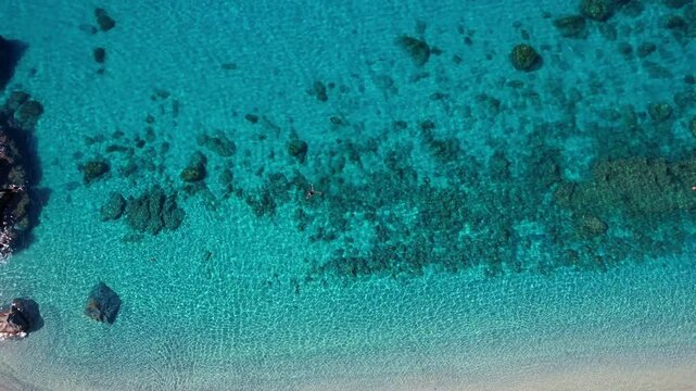 4K Aerial drone video of one of the most beautiful beaches in the world with turquoise clear blue water and white sand with big rocks on a sunny summer day. Marinella di Zambrone Paradiso Tropea Italy