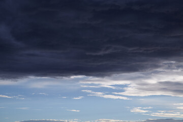 Dark storm clouds cover the blue sky, approaching storm, sky before the rain.