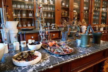 Chemistry flasks with liquids, herbs of medicinal plants in an old pharmacy