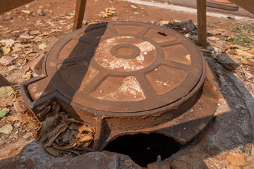 Manhole cover, sawhorse and traffic cone