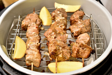 The meat is cooked in a multicooker on a grill together with potatoes.