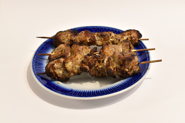 Grilled meat lies on a plate. Top view.