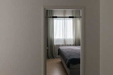 A pull-up bar is set up in the interior. In the background, there is a bedroom interior.