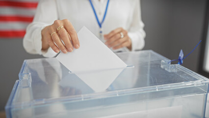 A mature woman is casting a ballot at a voting center with a us flag backdrop, symbolizing...