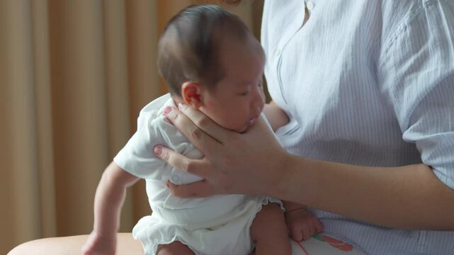 A mother gently pats her baby&rsquo;s back to release trapped gas after feeding, helping the little one feel more comfortable and content.