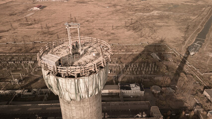 Dangerous work at height.Construction site of a power plant a high chimney.A renovation is smokestack.Contractor repairing a chimney at a highrise.Workers in a hard hat.Dangerous work at the high site