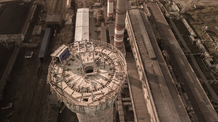 Dangerous work at height.Construction site of a power plant a high chimney.A renovation is smokestack.Contractor repairing a chimney at a highrise.Workers in a hard hat.Dangerous work at the high site