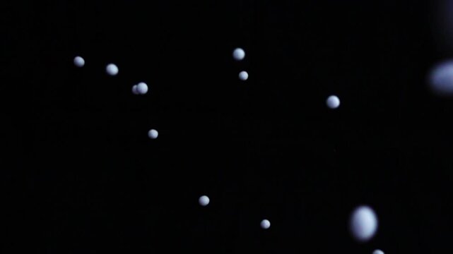 Coffee beans slow motion in black background.