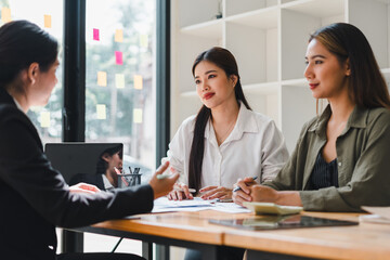 Professional women engaged in business meeting, discussing ideas and strategies. atmosphere is collaborative and focused, highlighting teamwork and communication