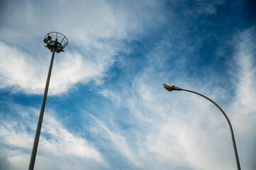 The high mast lighting on the blue sky with a cloud