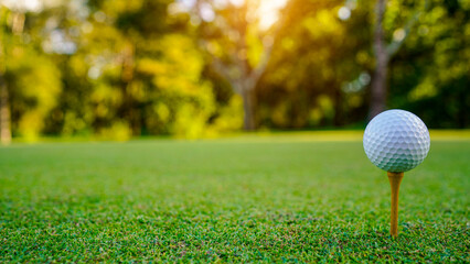 golf ball on tee in beautiful golf course with sunset.