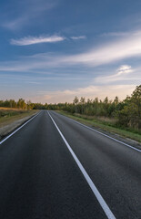 A long, empty road with a blue sky in the background