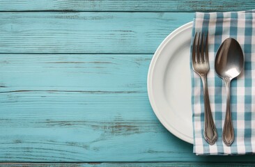 Rustic dining setup with vintage cutlery on a blue wooden table and checkered napkin