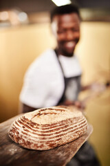 Black man, bread and wood board for baker, small business owner and pastry kitchen workshop. African chef, confidence and catering for coffee shop, retail and cafe startup for restaurant industry