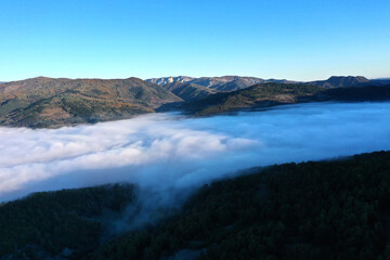 Aerial view of autumn morning mist and clouds in the valley