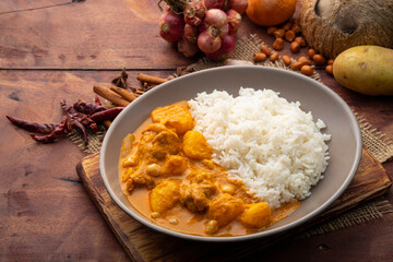 Massaman Curry with Chicken and Potatoes with cooked rice in a plate