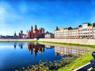 Beautiful houses on the Bruges waterfront in Yoshkar-Ola. Beautiful waterfront houses along the Bruges-style canal in Yoshkar-Ola under clear blue sky