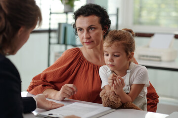 Woman with her little girl discussing application with social worker