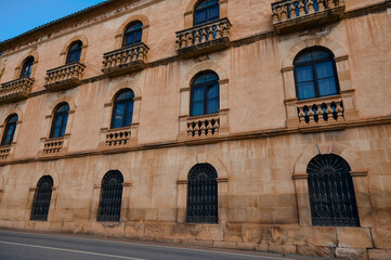 Historic stone building facade with arched windows and balconies