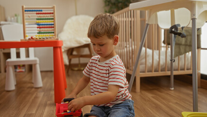 Toddler boy playing indoors at kindergarten with toys surrounded by educational games and furniture