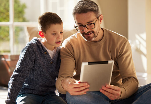 Home, father and boy with tablet, love and bonding together with happiness, connection and social media. Single parent, dad or son with tech, talk or digital app with internet, website info or relax