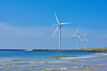 Outdoor, ocean and wind turbine for green power, sustainability and renewable energy in nature. Beach, eco and infrastructure by sea with carbon capture and system for clean electricity generation