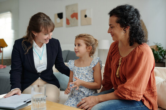 Social worker talking to child while visiting to their family at home