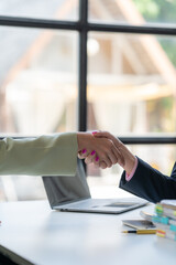Handshake of Trust: A close-up shot of two business professionals shaking hands, signifying a...