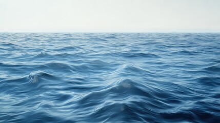 Fototapeta premium A serene sea surface with light waves gently moving under the afternoon sun, creating smooth reflections.