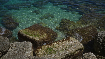 Clear turquoise waters and rocky shoreline in gallipoli, puglia, italy showcase the picturesque coastal beauty of this european destination.