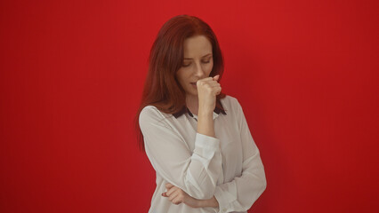 A young woman is coughing over an isolated red background, depicting sickness or discomfort.