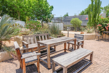 Obraz premium Empty Wooden Table and chairs inside desert House or hotel with bougainvillea flower and cactus,summer spanish bougainvillea flowers with blue sky,selective focus.