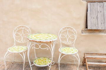 Metal table and chair inside desert House or hotel with cactus and blue sky,villa house building facade exterior mediterranean architecture in desert,selective focus..